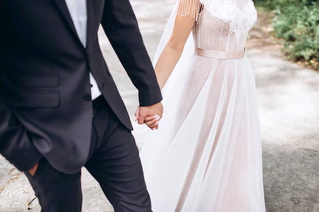 Abrázame y nunca me sueltes. Felices recién casados se dan la mano