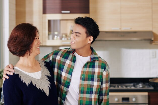 Abrazando a madre e hijo en la cocina