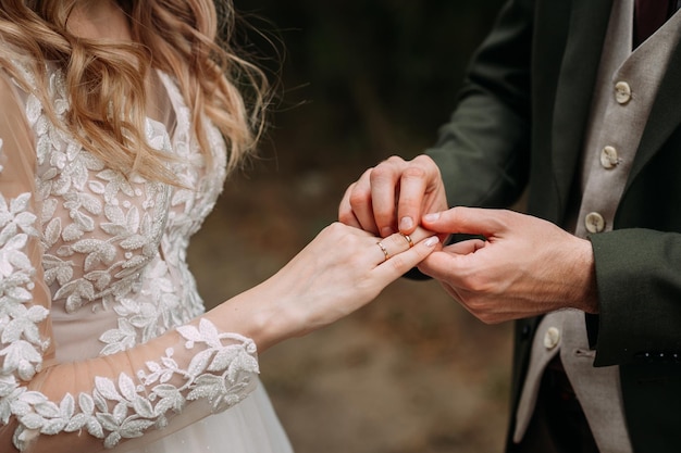 Abrazando las manos de los recién casados con anillos de boda 4380