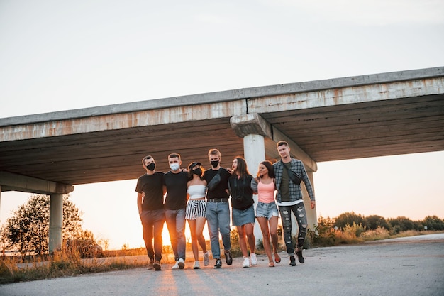 Abrazándose unos a otros Grupo de jóvenes amigos alegres divirtiéndose juntos Fiesta al aire libre