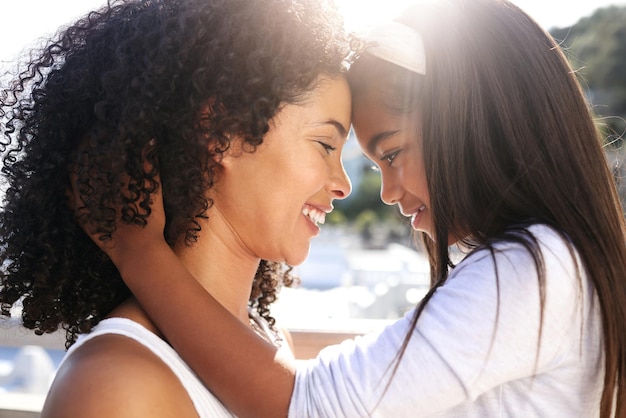 Abrazar el amor y la madre y el niño en la playa con un vínculo de felicidad y afecto Admirando la diversión y la madre y la niña africanas abrazándose para apreciar el día de la madre y cuidar juntos junto al océano