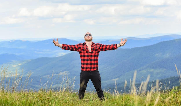 Foto abrazar todo el mundo concepto de senderismo ocio activo chico disfrutar de la libertad masculinidad y energía masculina lograr la libertad libre y salvaje valor de la libertad autosuficiente hombre parado en la cima de la montaña