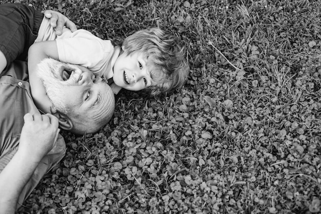 Abrazo y abrazo en la hierba verde abuelo y nieto Abuelo con hijo y nieto divirtiéndose