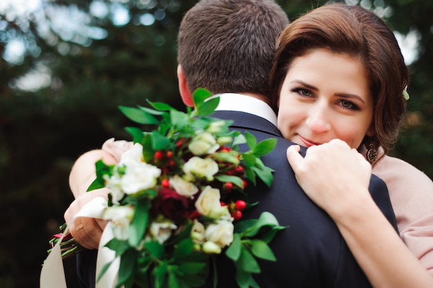 Abrazo romántico de los recién casados. Pareja camina en el parque.