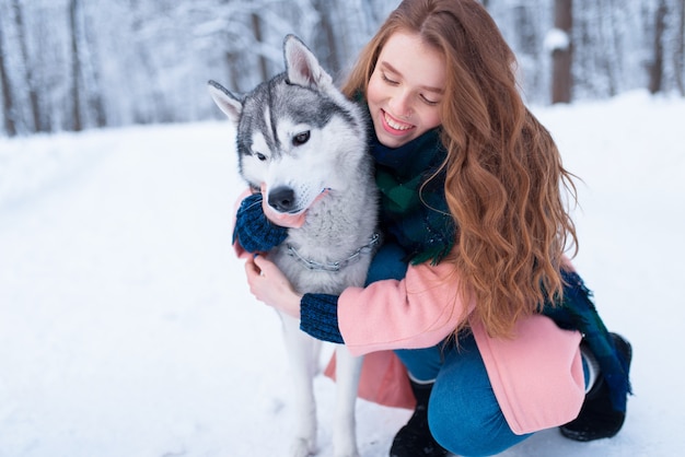 Abrazos de mujer bonita con husky siberiano