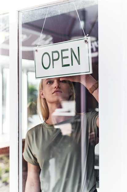 Abre el letrero y la mujer en la ventana en el salón de trabajo y peluquería en la ciudad el orgullo del propietario de una pequeña empresa y la mujer empresaria para el trabajo tienda y puerta para cosméticos y puesta en marcha en Nueva York
