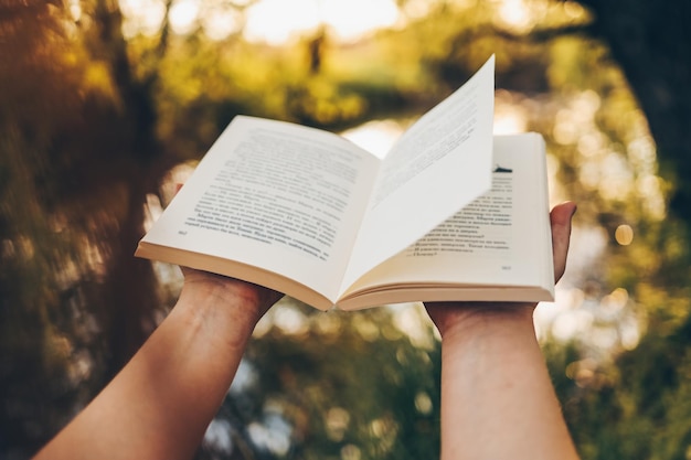 Abre un libro en un fondo de puesta de sol Leer estudiando en la escuela Leer un libro al aire libre