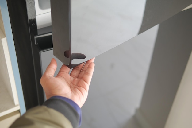 Abre la puerta del refrigerador con la mano.