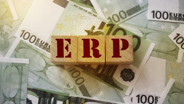 Abreviatura ERP Enterprise Resource Planning em cubos de madeira em 100 notas de euro Conceito de análise de negócios