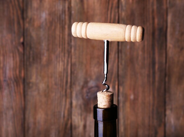 Foto abridor de botella en primer plano sobre un fondo de madera