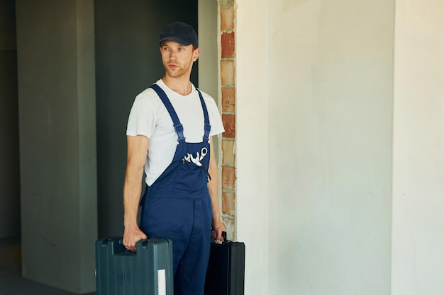 Abriendo el caso Joven trabajando en uniforme en la construcción durante el día