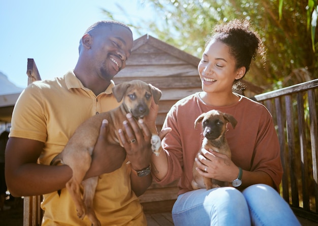 Abrigo e resgate de cães com um casal negro segurando um filhote para adoção em um canil de bem-estar Ajude caninos e voluntários com um homem e uma mulher que adotam cães de uma organização de caridade