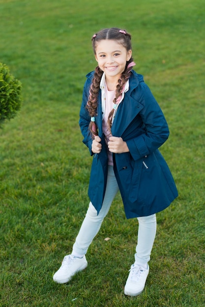 Abrigo de moda Chica cara linda cabello trenzado posando abrigo en el parque de primavera Ropa para paseos de primavera Modelo de moda pequeña Ropa y accesorios Ropa de niño gabardina Abrigo de primavera Debe tener concepto