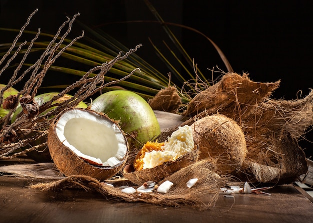 Foto abrir cocos verdes y cocos maduros con cocada dulce en mesa