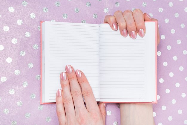 Abrir cuaderno en blanco en manos femeninas.