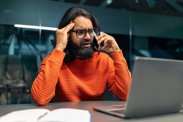 Abrumado hombre indio es profesional hablando por teléfono