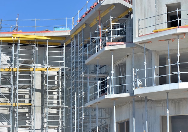 Abschluss auf konkreter Fassade mit Baugerüst eines Wohnsitzes im Gebäude auf Arbeitsplatz