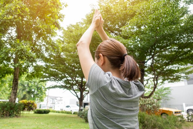 Abschluss oben der Frau, die Yoga im grünen Garten tut