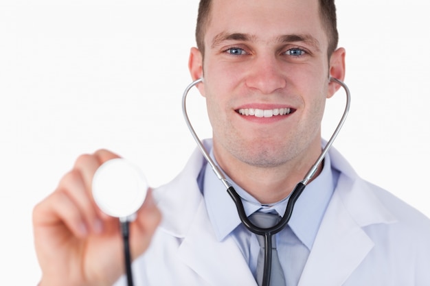Abschluss oben lächelnden Doktors, der Stethoskop verwendet