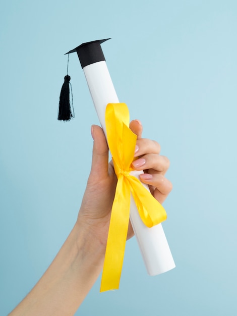 Abschlussdiplom mit gelbem Band und akademischer Kappe