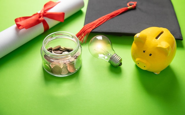 Abschlussmütze, Diplommünzen, Sparsamkeit und Glühbirne