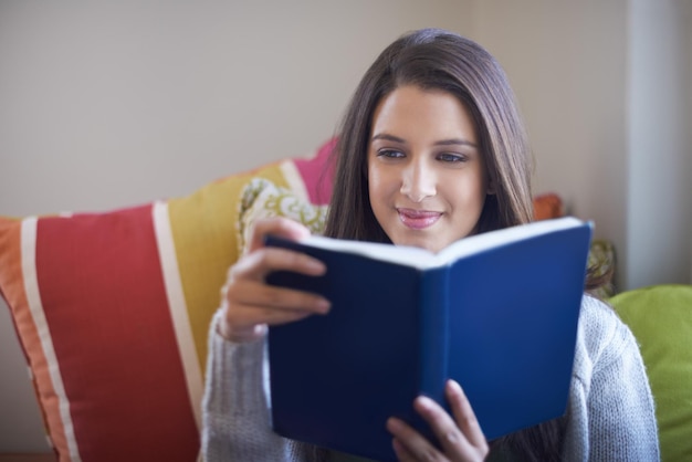 Absorto en un excelente libro Vista recortada de una mujer joven disfrutando de un buen libro