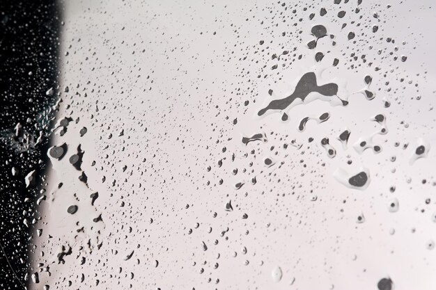 Abstracción fotográfica de gotas de agua ordinarias en un espejo reflectante