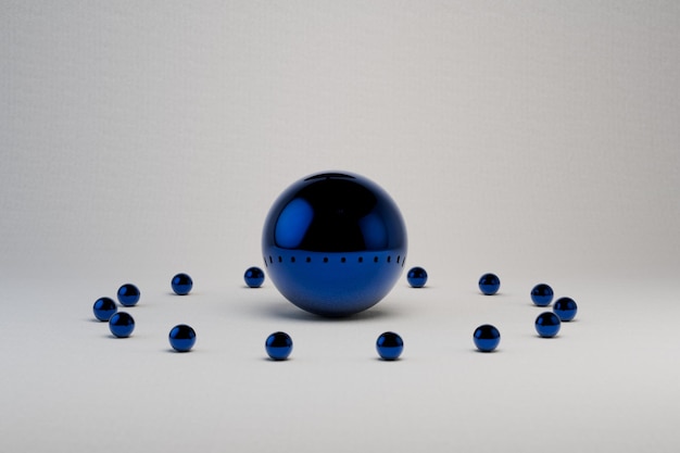 abstracción. una gran esfera azul en medio de un fondo blanco con pequeñas bolas azules alrededor