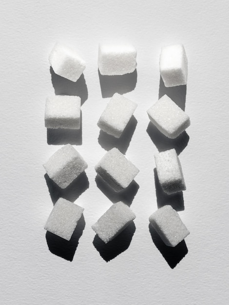Abstract flat lay top down still life cubos de açúcar criativamente colocados em fundo branco em luz áspera