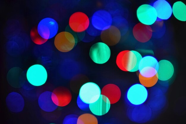 Foto abstracto de cores fundos desfocados bokeh luzes de natal em um fundo preto puro preparando-se para as férias