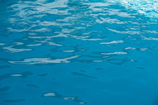 Abstrakte Kräuselwelle und klare türkisfarbene Wasseroberfläche in der blauen Wasserwelle des Swimmingpools für Hintergrund und abstraktes Design