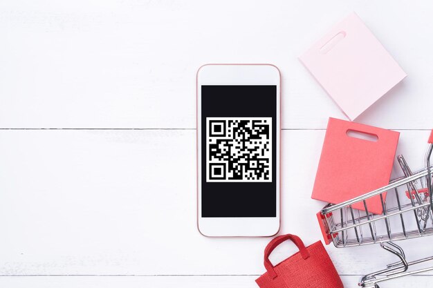 Abstrakte Online-Shopping-Mobilzahlung mit QR-Code-Design-Konzeptelement bunte Karren-Papiertüte auf Holztisch-Hintergrund-Draufsicht flach gelegt