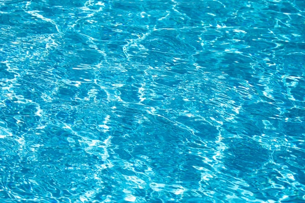 Abstrakte Wellenwelle und klare türkisfarbene Wasseroberfläche in der blauen Wasserwelle des Schwimmbeckens für Hinterg...