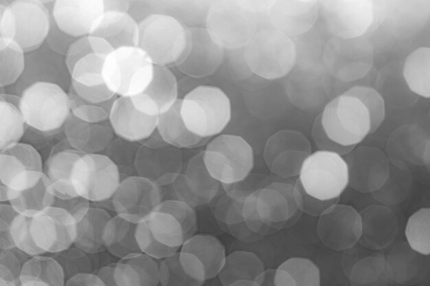 Abstrakter grauer Hintergrund mit verschwommenem Bokeh-Licht. Schöner grau-schwarz-weißer Bokeh-Hintergrund aus dem Naturwald