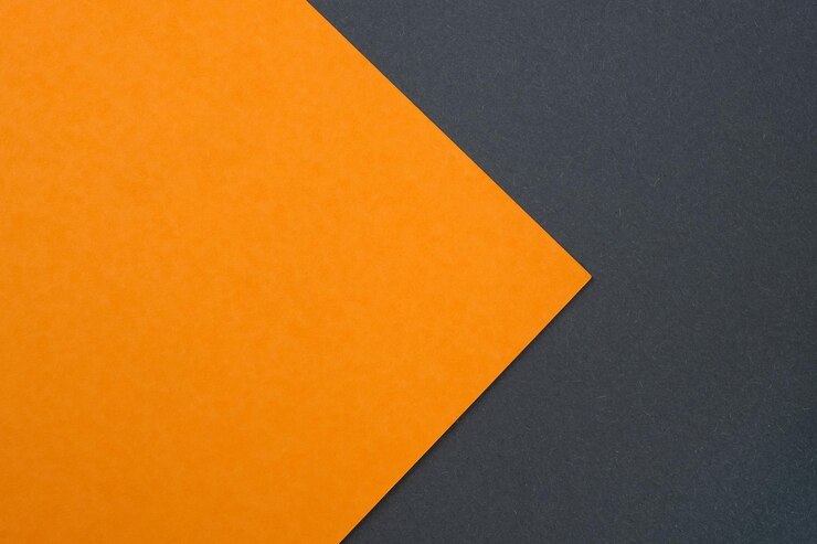 Abstrakter Hintergrund aus Blättern aus orangefarbenem und schwarzem Papier Orangefarbener Karton auf einem Hintergrund aus schwarzem Karton Draufsicht Dickes Papier in verschiedenen Farben oben Kreatives Design des abstrakten Papiers