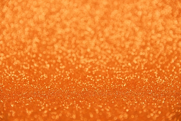 Abstrakter hintergrund aus orangefarbenem bokeh, defokussierten, verschwommenen lichtern und glitzerndem funkeln