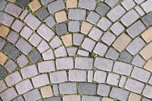 Abstrakter Hintergrund der Straße von Steinpflastersteinen, die mit Wellen ausgekleidet sind