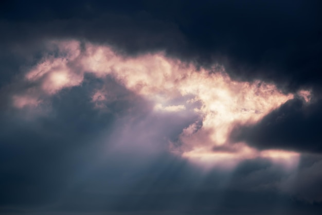 Abstrakter Hintergrund mit erstaunlichem dramatischem Himmel bei Sonnenuntergang Sonnenstrahlen, die durch die Wolken scheinen