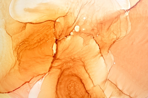 Abstrakter ockerfarbener Aquarellhintergrund. Gelb-orange-braune Farbflecken und Flecken im Wasser, luxuriöse flüssige flüssige Kunsttapete