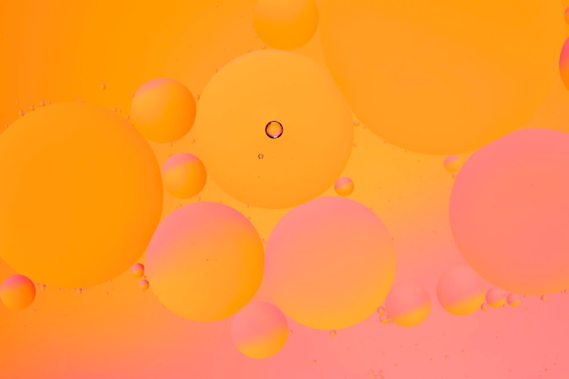 Abstrakter orange-rosa Hintergrund mit Ölkreisen auf der Wasseroberfläche
