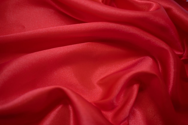 Abstrakter roter Satin-seidiger Stoff-Textil-Drap mit Falten-Wellen-Falten-Hintergrund