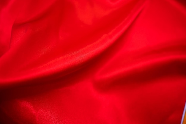 Abstrakter roter Satin-seidiger Stoff-Textil-Drap mit Falten-Wellen-Falten-Hintergrund