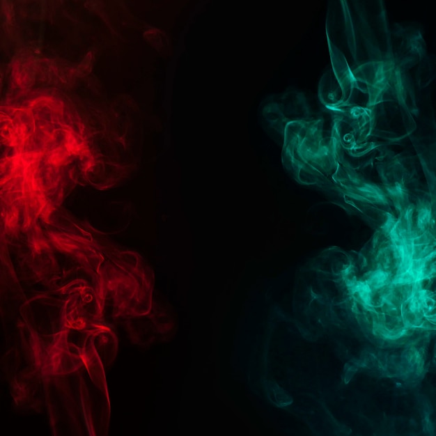 Foto abstrakter roter und grüner rauch, der über den schwarzen hintergrund fließt