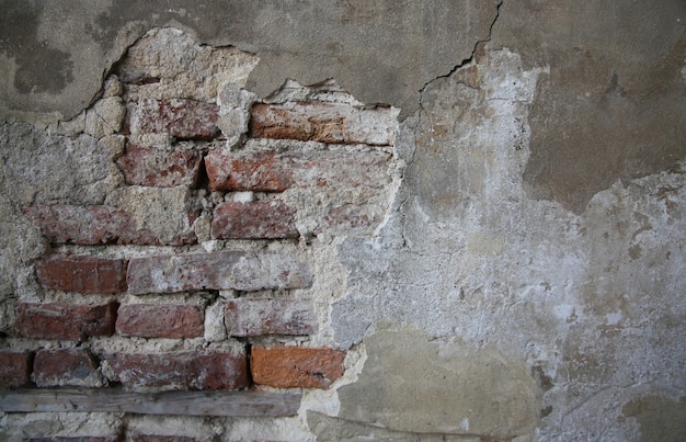 Abstrakter Teil der alten Backsteinmauer mit ruiniertem Putz für Vintage-Hintergrund und Tapeten im Sepia-Stil