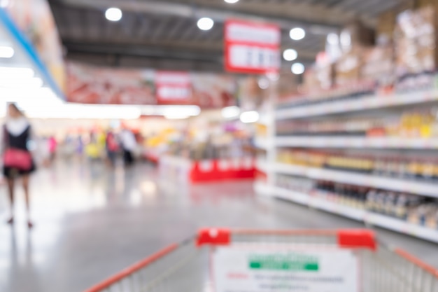 Abstrakter Unschärfehintergrund innerhalb des Supermarktes. Einkaufswagen und Einkaufen im Supermarktkonzept.