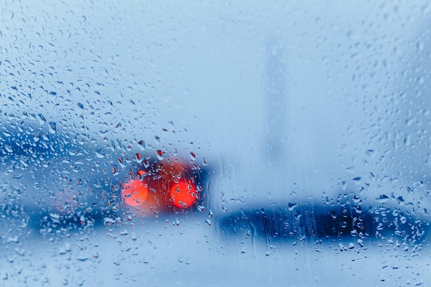 Abstrakter Winterhintergrund. Eine durch Glas gesehene Straße mit Kondensationstropfen