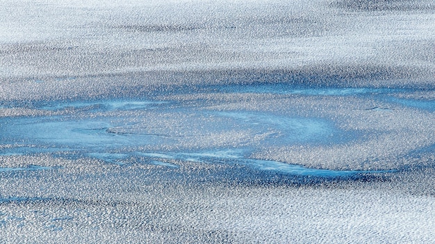 Abstrakter Winterhintergrund mit Schneebeschaffenheit auf Eis