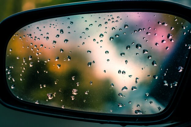 Abstraktes Bild von Regentropfen auf dem Seitenspiegel des Autos