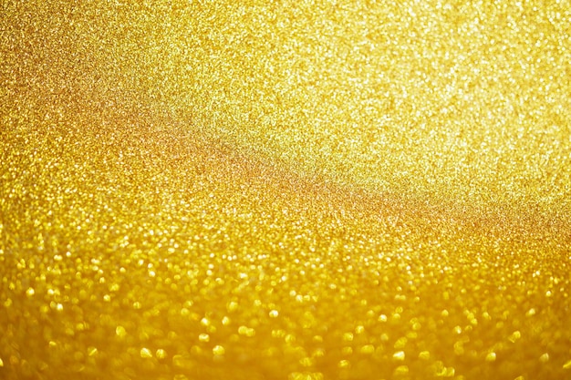 Abstraktes Goldfunkeln funkelt mit Bokeh-hellem Hintergrund