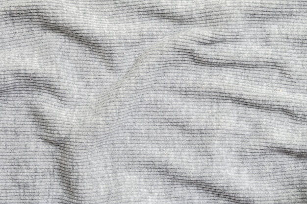 Abstraktes Muster der Nahaufnahme am faltigen grauen Frauenkleidungs-strukturierten Hintergrund